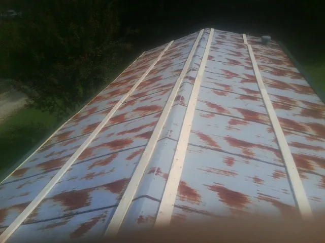 Rusted metal roof panels with new wood purlins before replacement — Storm Damage Roof Repair in Rosman by Roofing Brothers