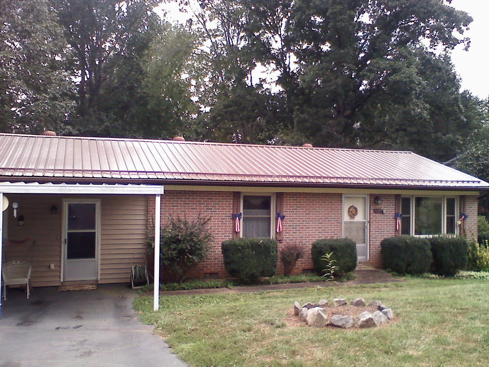 Bronze metal roof and carport on a brick ranch home — Roof Repair work by our crew in Rosman