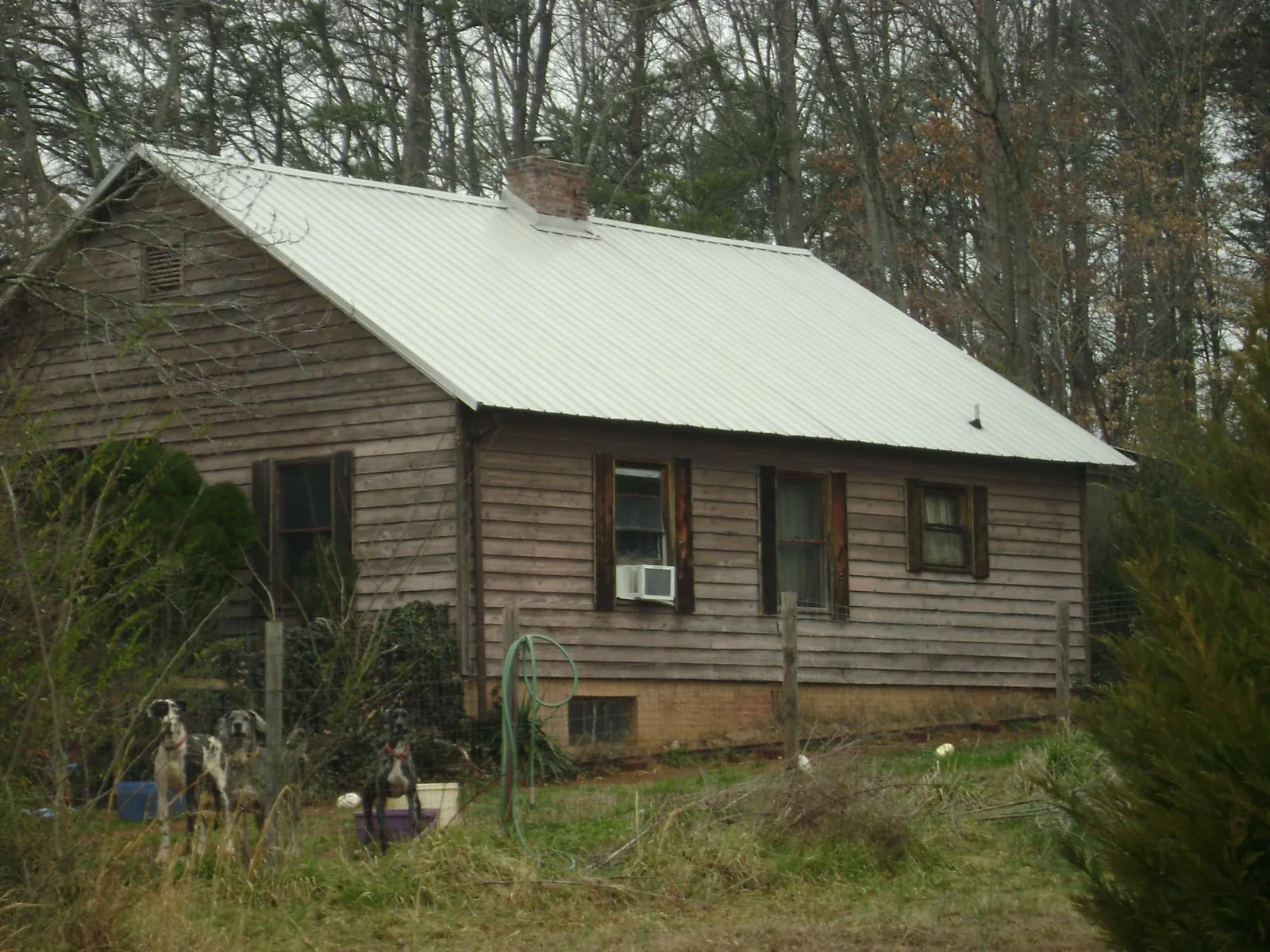 White metal roof on an old wood sided farmhouse, from a Metal Roof Installation job in Rosman